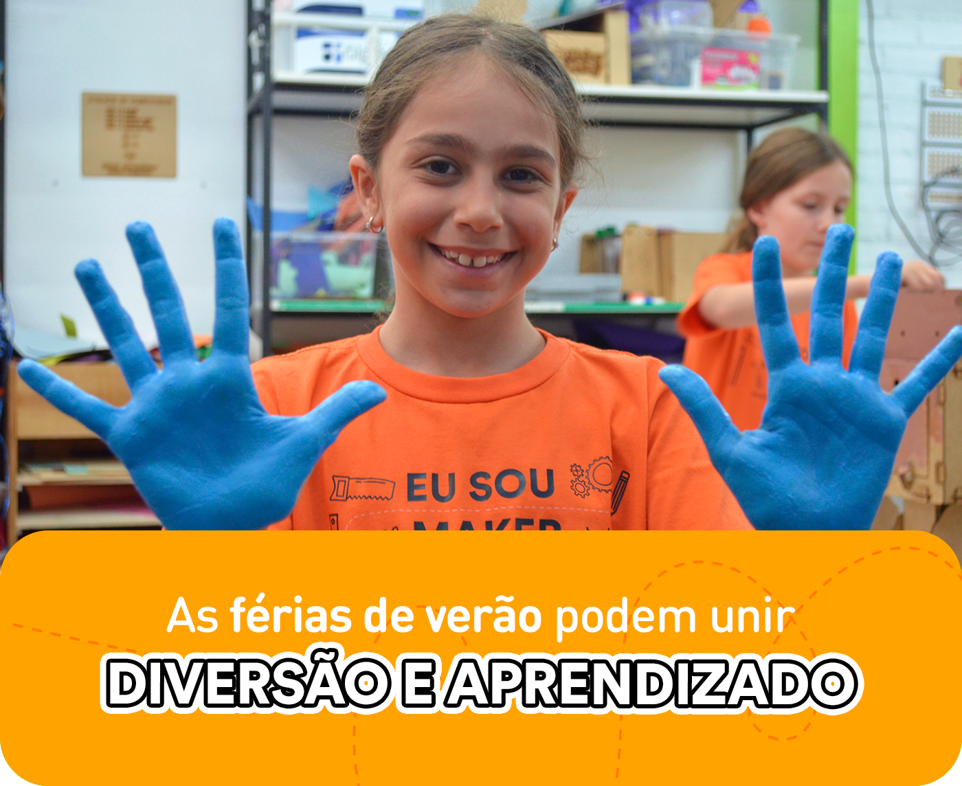 A imagem leva uma menina sorrindo, com as mãos à mostra pintadas de azul enquanto pratica atividades em suas férias de verão.